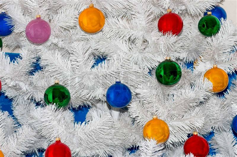 Colored Christmas toys on a white Christmas tree, stock photo