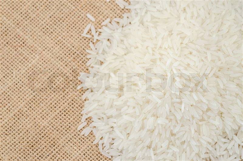 Raw rice on sack background, stock photo