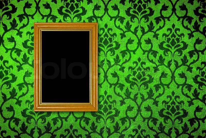Gold frame on a vintage green wall background, stock photo