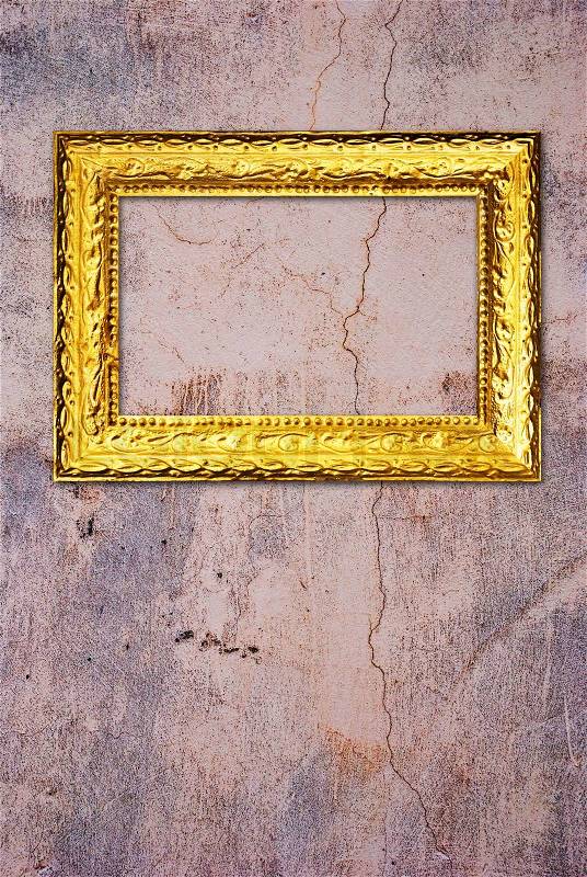Gold frame on a old wall background, stock photo