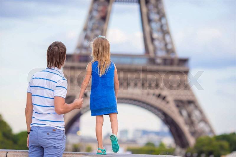 Little cute girl and her father in Paris near Eiffel Tower during summer french vacation, stock photo