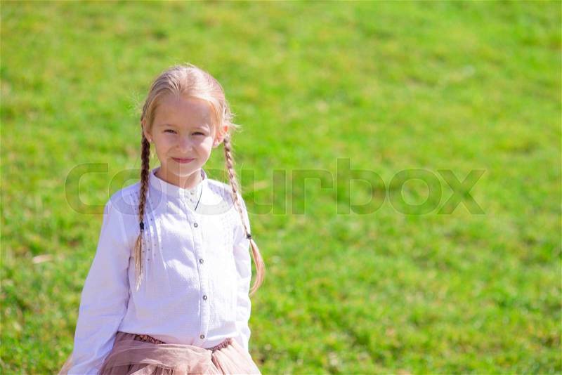 Adorable little girl near the Eiffel tower during summer vacation in Paris, stock photo