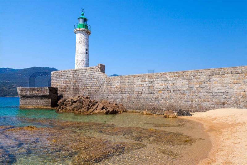 White stone lighthouse tower on the pier. Entrance to Propriano, Corsica island, France, stock photo
