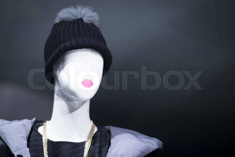 Shop dummy fashion mannequin in department store boutique window wearing current trends in garments, stock photo