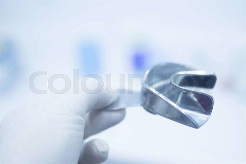 Metal dental mold dentist clay teeth plate ceramic colored cast model in dental clinic office surgery used for patient diagnosis and treatment by filling with resin gum to show the shape and condition of patients teeth, stock photo