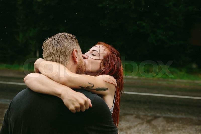 Beautiful couple kissing outside in the rain, stock photo