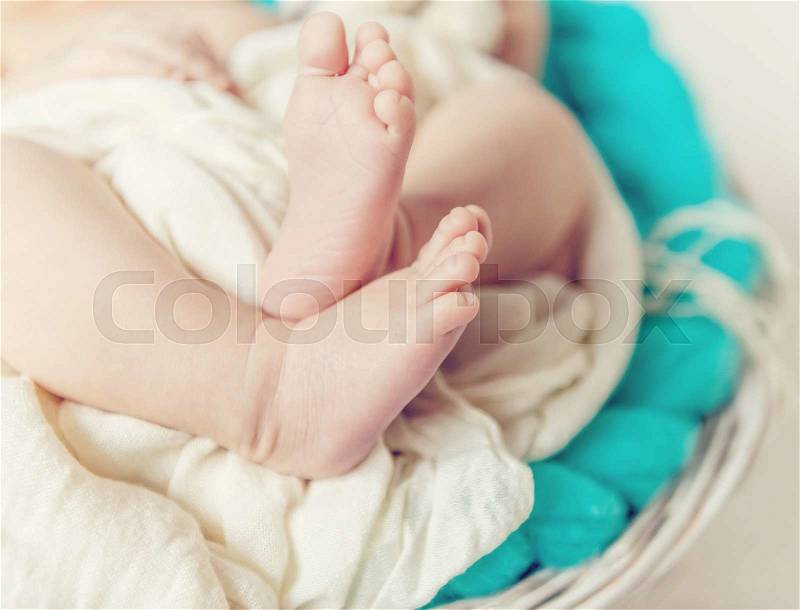 Lovely little feet under soft blanket, stock photo