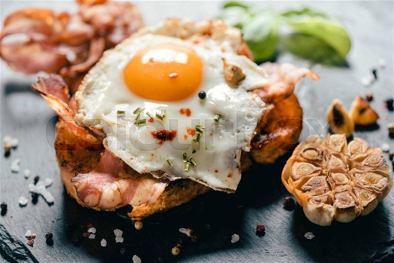 Sandwich with fried egg and bacon on grilled bread with onion,selective focus , stock photo