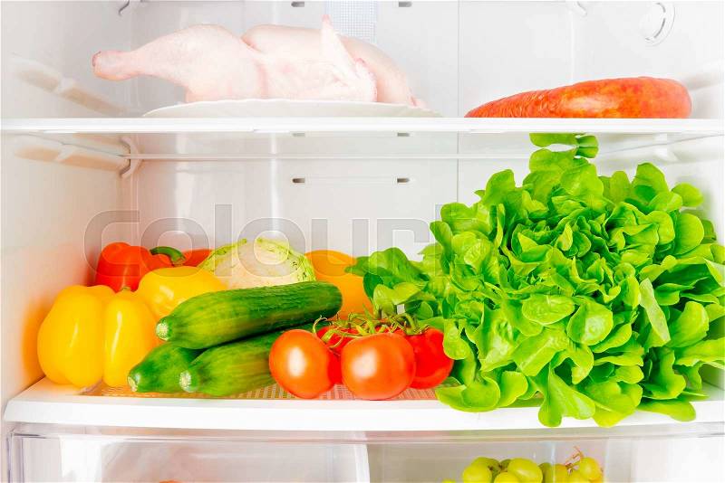 fresh vegetables and a bird on the shelf of the refrigerator a horizontal picture , stock photo