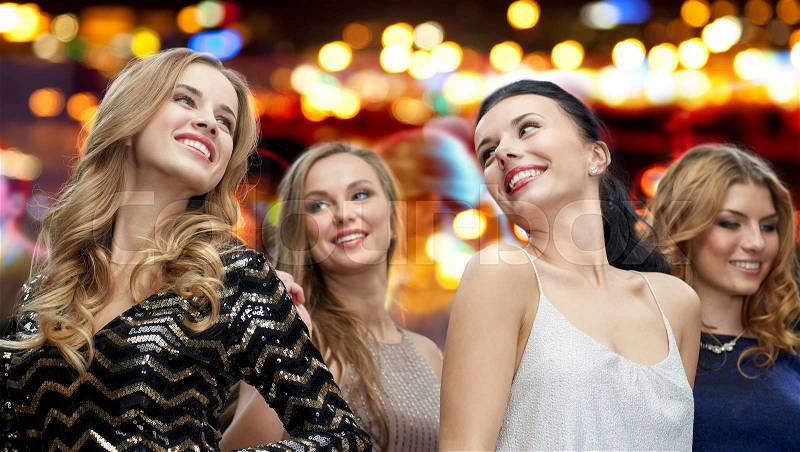 Party, holidays, nightlife and people concept - happy young women dancing over night club disco lights background, stock photo
