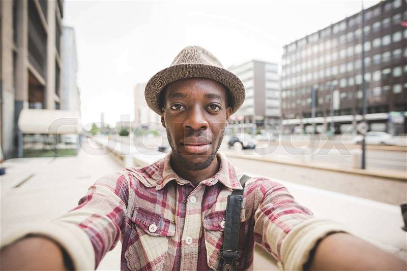 Half length of young handsome afro black man taking a selfie, looking in camera, smiling - vanity, social network concept, stock photo