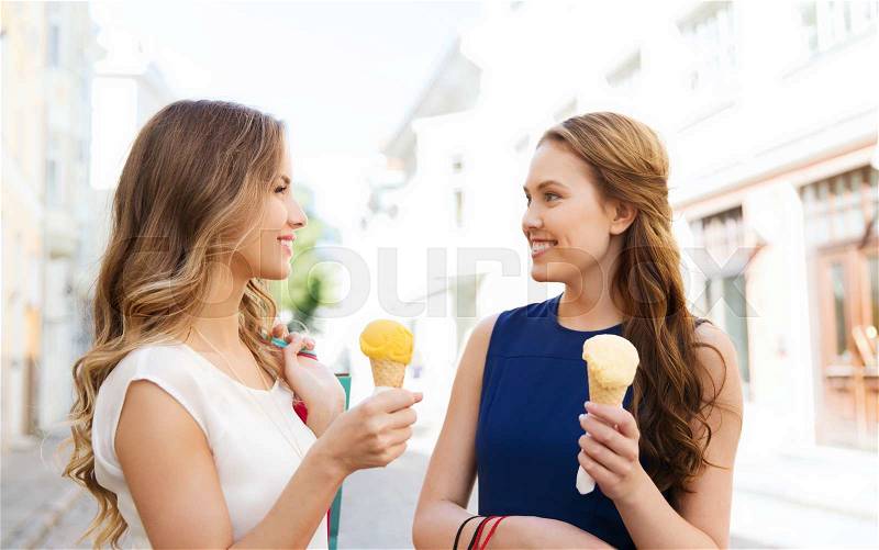Sale, consumerism, summer and people concept - happy young women with shopping bags and ice cream talking on city street, stock photo