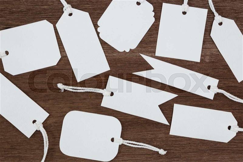 Blank white paper tags label on wood background, stock photo