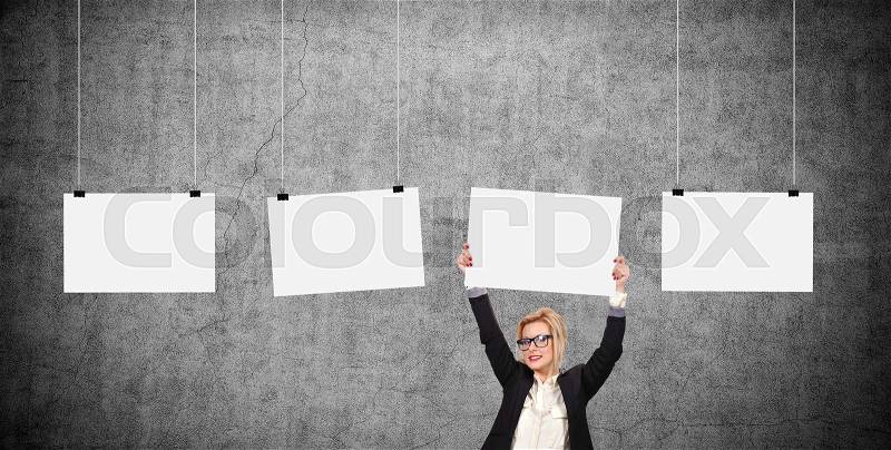 Businesswoman holding blank poster over head. Three blank poster hanging on a rope, stock photo