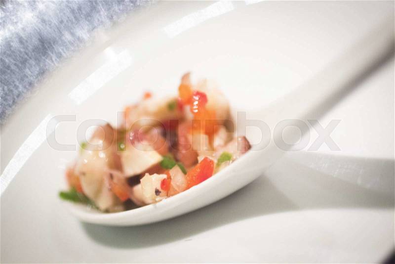 Dish of starter vegetable and seafood on plate in restaurant on table cloth, stock photo