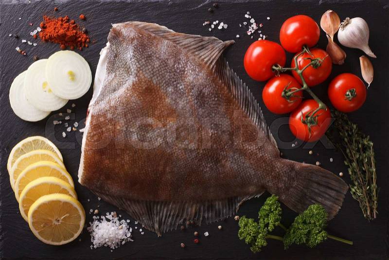 Fresh raw plaice with ingredients on a slate board closeup. horizontal view from above , stock photo