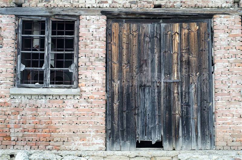 Old wooden gate at brick building, stock photo