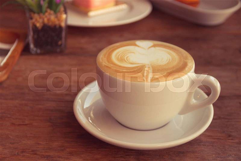Close up cup of Coffee, latte on the wooden table - Vintage Filter Effect, stock photo