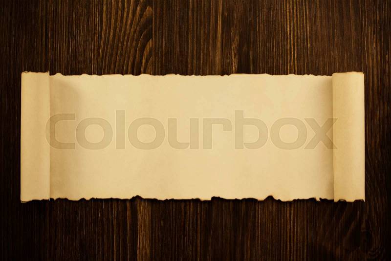 Parchment scroll on wooden background, stock photo