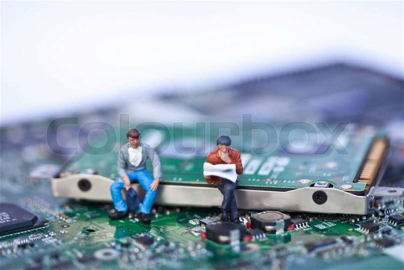 Macro picture of computer electronics with people sitting, stock photo