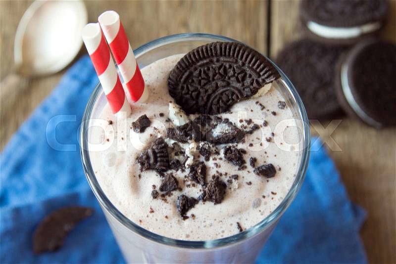 Homemade milkshake (chocolate smoothie) with cookies on rustic wooden table close up, stock photo