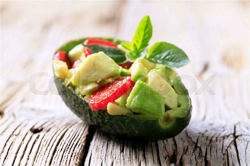 Avocado salad served in an avocado peel, stock photo