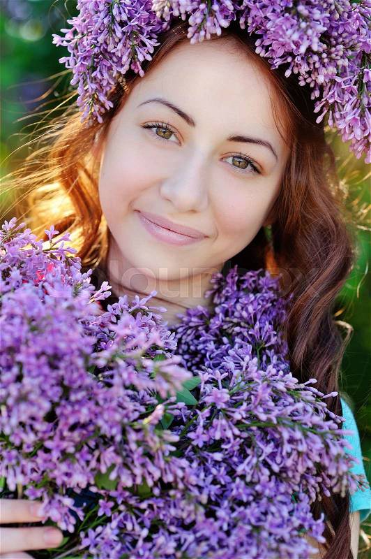 Beautiful girl with a bouquet of lilacs and a wreath of lilac, stock photo