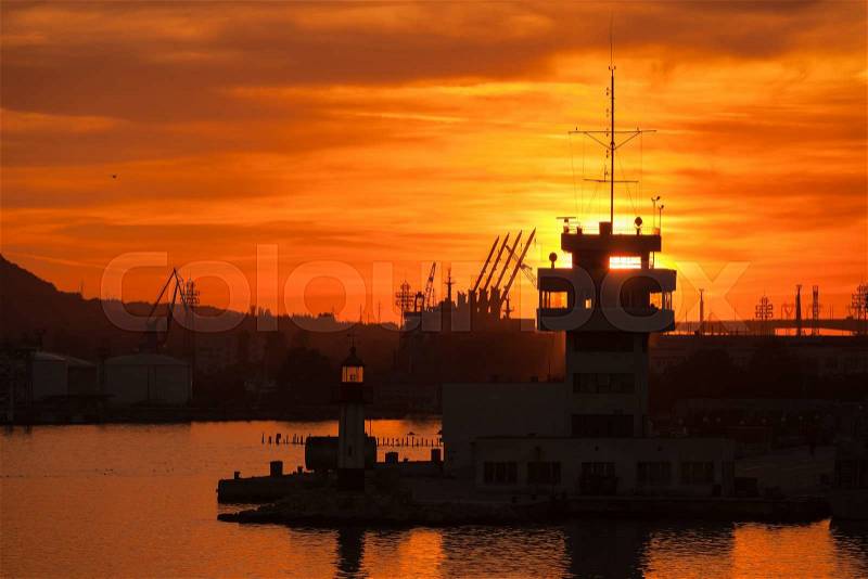 Silhouettes of cranes and buildings in Varna port at sunset, stock photo