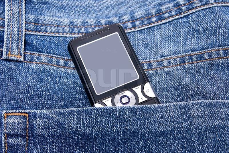 Mobile phone in jeans pocket, stock photo