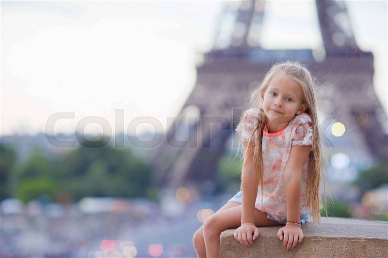 Adorable little girl background the Eiffel tower during summer vacation in Paris, stock photo