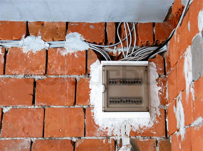 Electrical installations, safety fuses box on red brick wall, stock photo