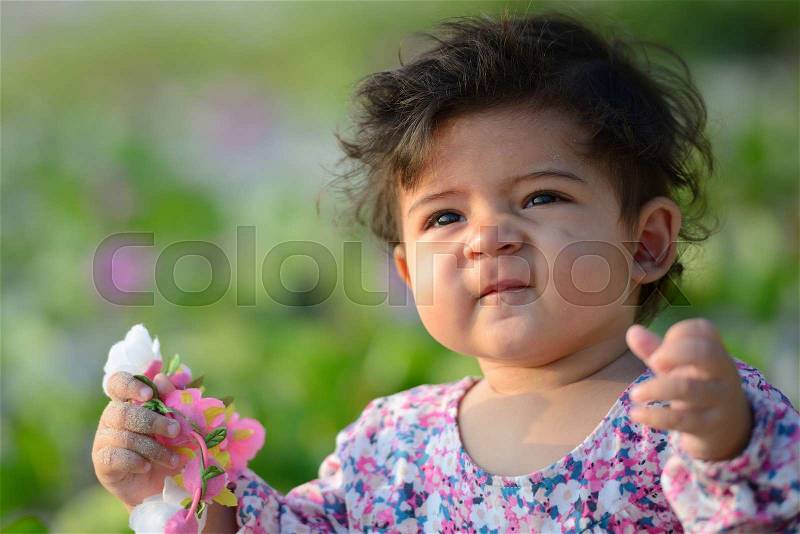 Closeup of cute adorable beautiful face of mixed race baby with innocent expression, stock photo