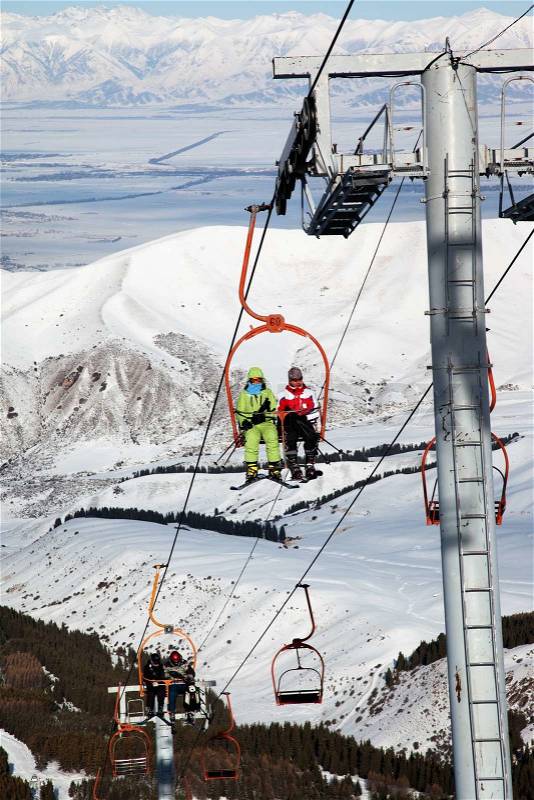Couple on ski elevator in winter mountains, stock photo