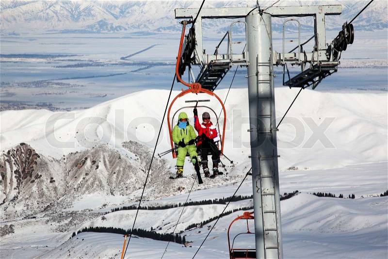 Couple on ski elevator in winter mountains, stock photo