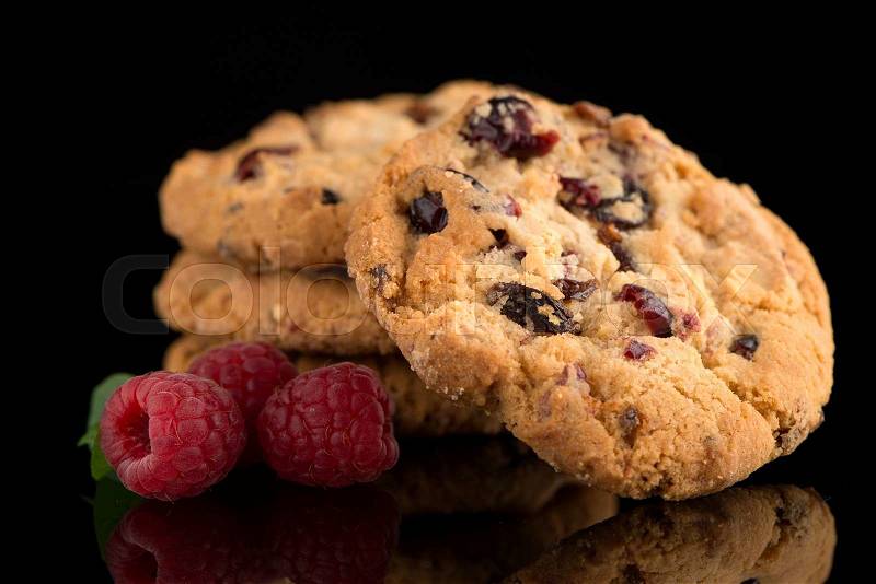 Dried fruits chip cookies and raspberries isolated on black background, stock photo