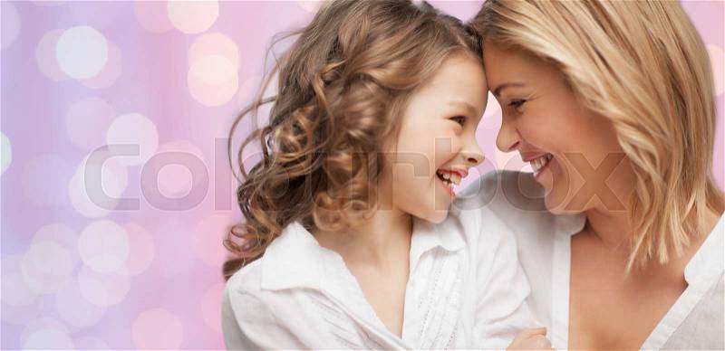 People, motherhood, family, holidays and adoption concept - happy mother and daughter hugging over holidays lights background, stock photo