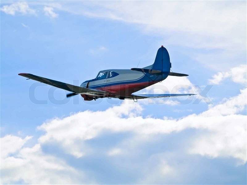 Single aeroplane flying in blue sky through the clouds, stock photo