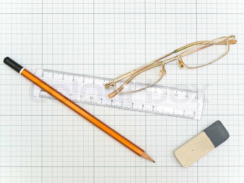 Glasses, pencil, eraser and ruler at the plotting paper, stock photo