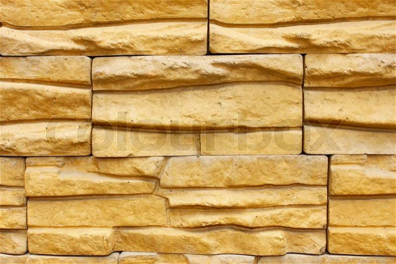 Fragment of walls covered with yellow decorative relief tiles, stock photo