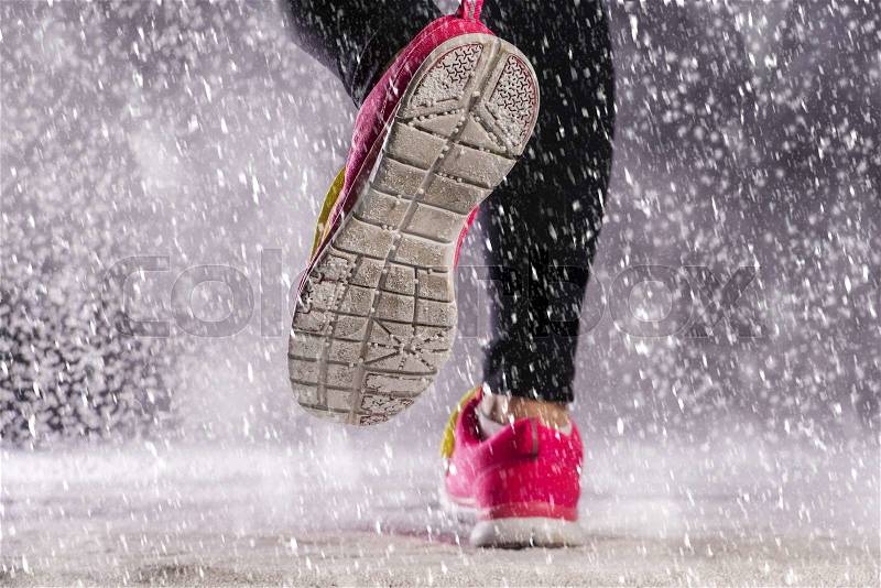 Athlete woman is running during winter training outside in cold snow weather, stock photo