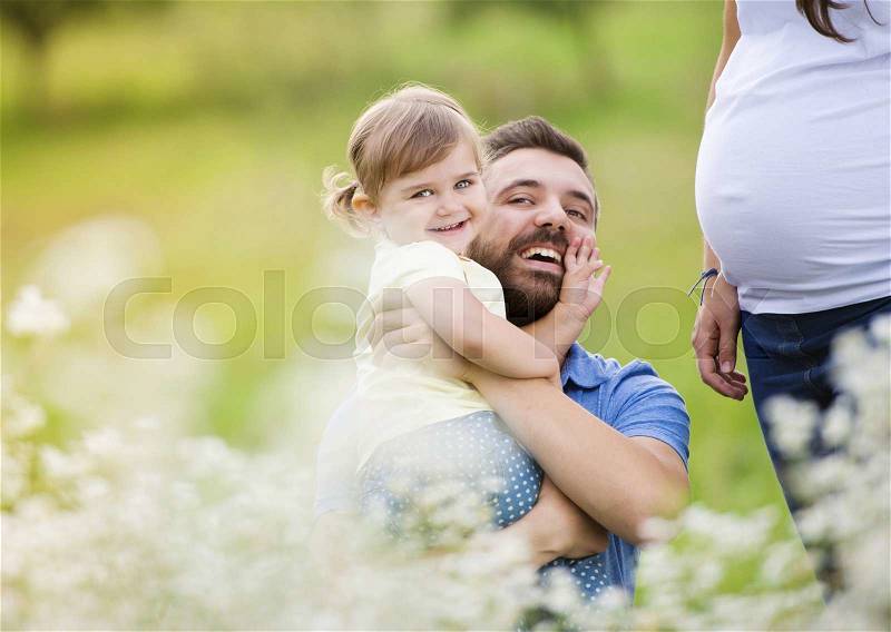 Happy pregnant family having fun in summer nature, stock photo
