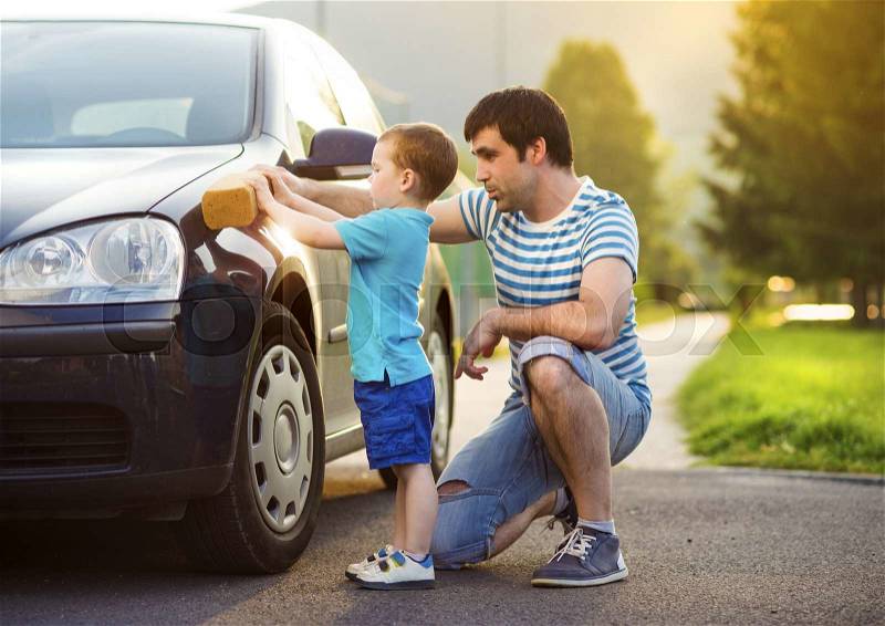 Young father with his little son washing car, stock photo