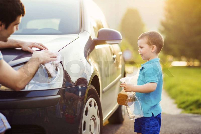 Young father with his little son washing car, stock photo
