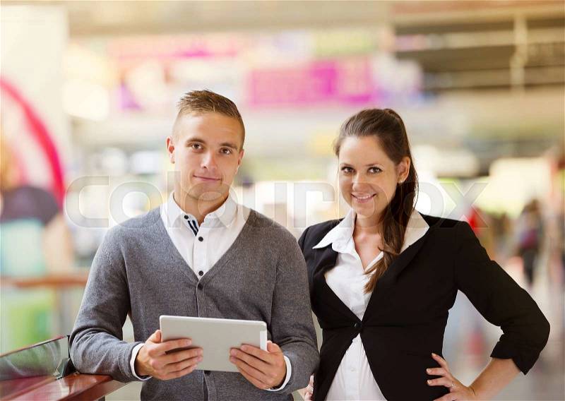 Businessman and businesswomen having a meeting in shopping mall. Woman is pregnant, stock photo