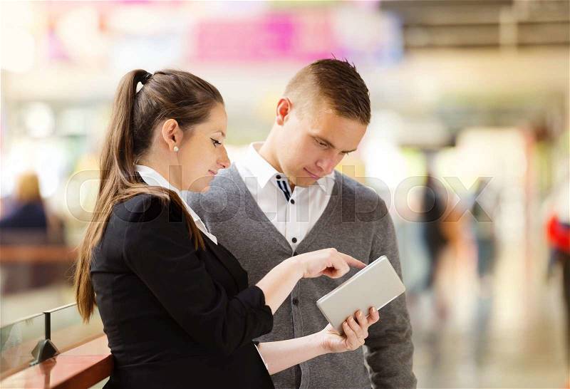 Businessman and businesswomen having a meeting in shopping mall. Woman is pregnant, stock photo