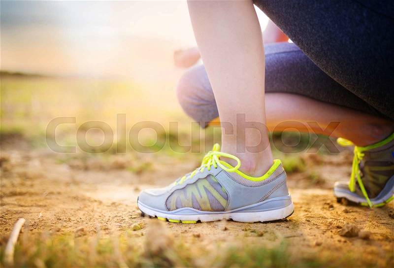 Runner woman feet running on countryside road, closeup on shoe, stock photo