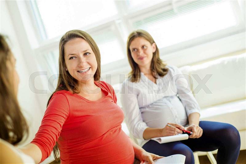 Happy pregnant women meeting at antenatal class in the hospital, stock photo
