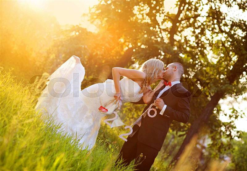 Happy bride and groom enjoying their wedding day in green nature, stock photo