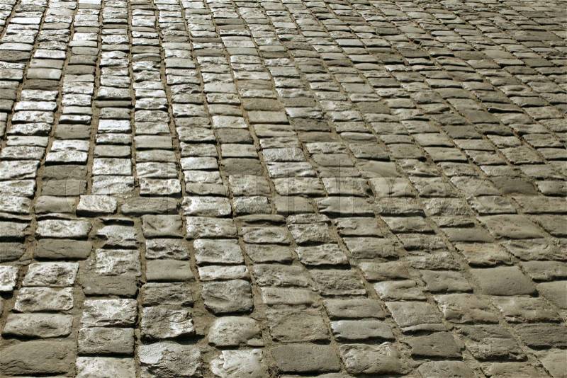 Part of urban square covered with cobblestone. Sunlight reflected on the stones, stock photo