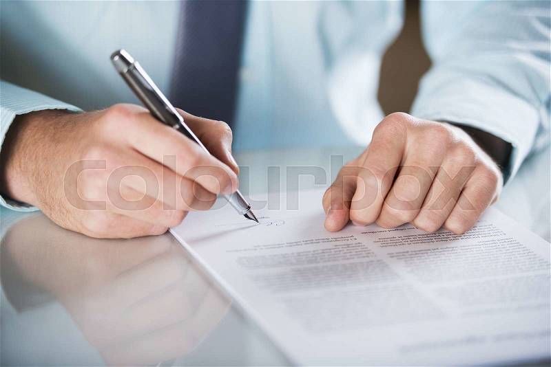 Businessman is signing a contract, business contract details, stock photo